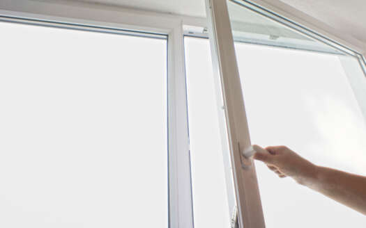 Hand öffnet Fenster zum Lüften – gesundes Wohnen Senden