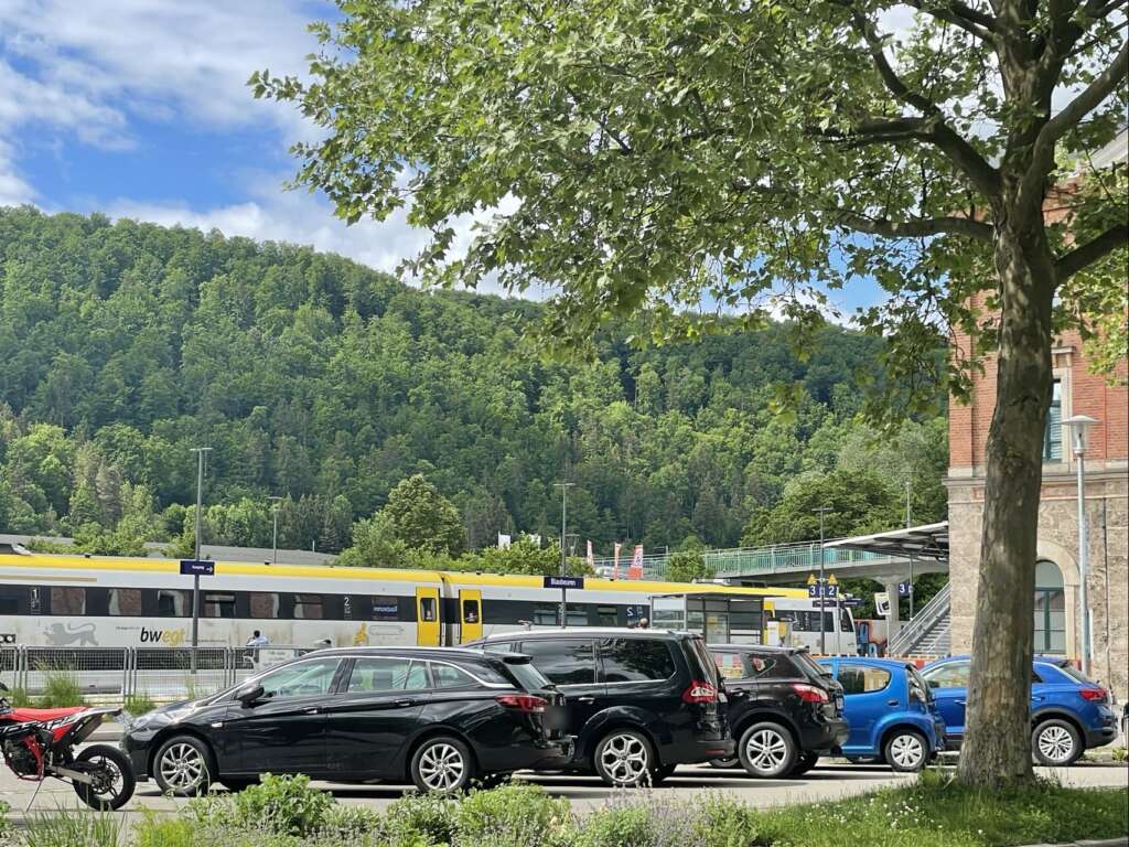Bahnhof Blaubeuren mit Regionalzug vor den bewaldeten Hängen des Blautals